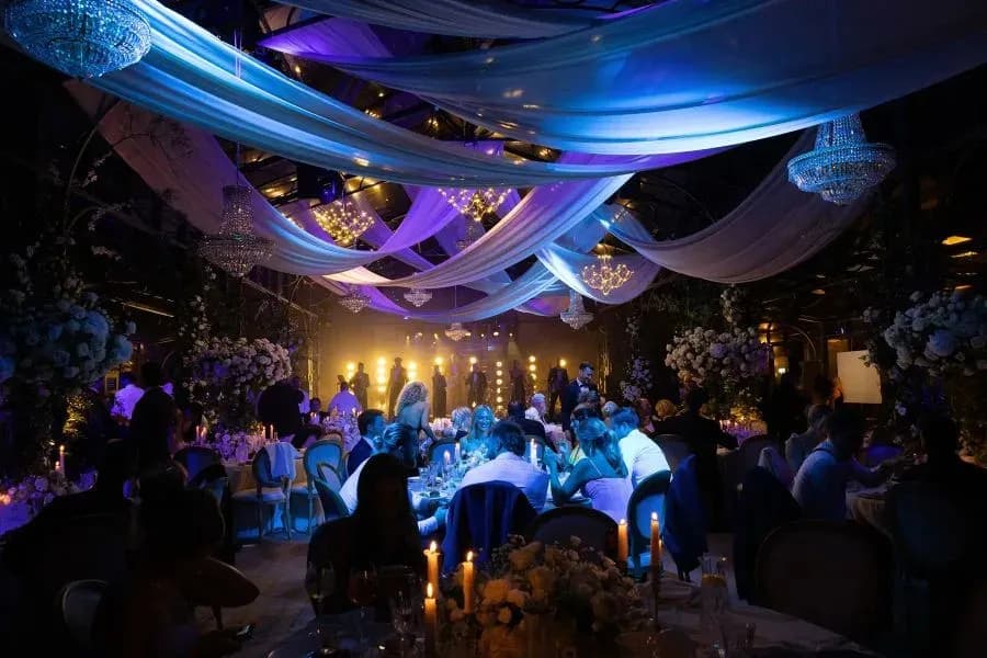 Luxury wedding reception in Italy with chandeliers, draped fabric and candlelit tables