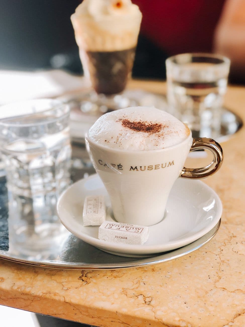 Close-up of a frothy cappuccino served at Café Museum with a stylish saucer.