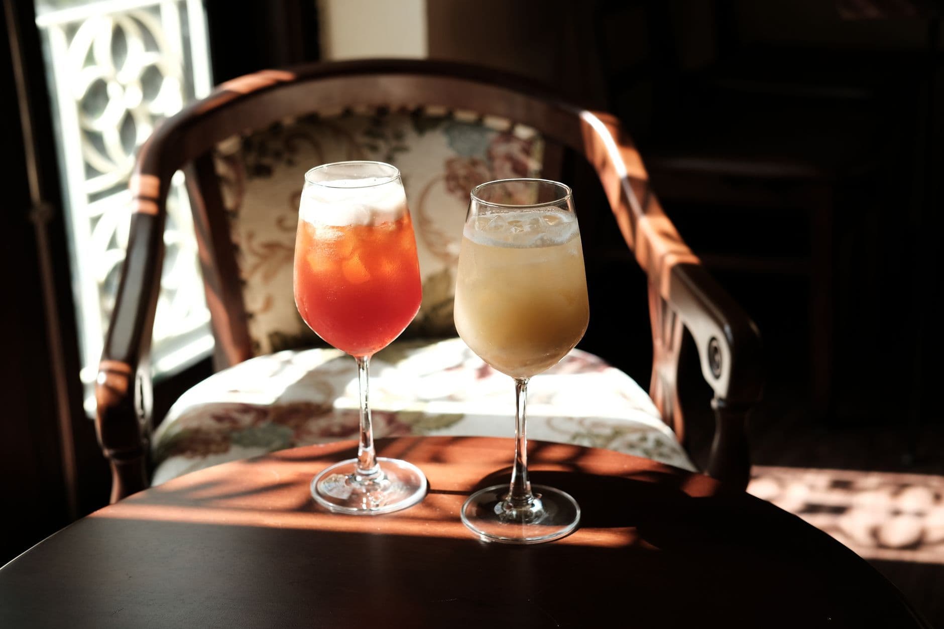 Two glasses of iced tea in a cozy cafe, sunlit ambiance creates a warm and inviting atmosphere.